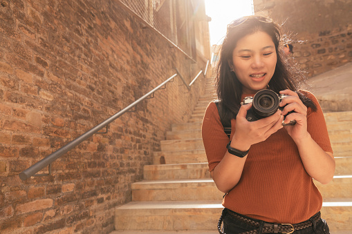 attractive asian female traveller tourism hand use camera sightseeing old stone stair hallway in cartagena spain with happiness and cheerful travel journey concept