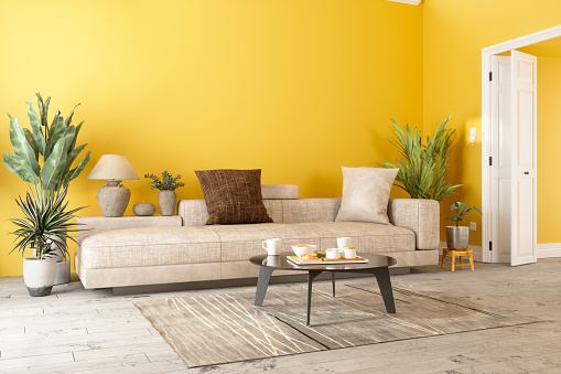 Moderno salón interior con sofá, plantas en macetas y pared de color amarillo photo