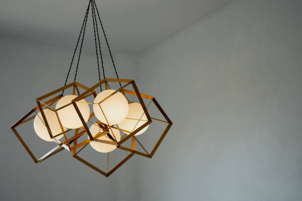 une lampe ronde avec un cadre rectangulaire en fer suspendu au plafond, éclairant en or. concept intérieur. - light fixture photos et images de collection