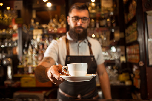 Bartender offering coffee to a customer