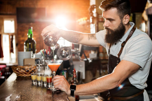 istock Close up of a bartender getting ready for party pouring alcohol cocktails 1320269733
