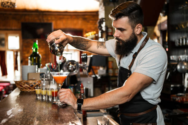 istock Close up of a bartender pouring alcohol cocktails 1320269742