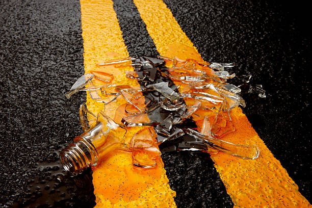 destrozadas botella de whisky en carretera - glass broken spilling drink fotografías e imágenes de stock