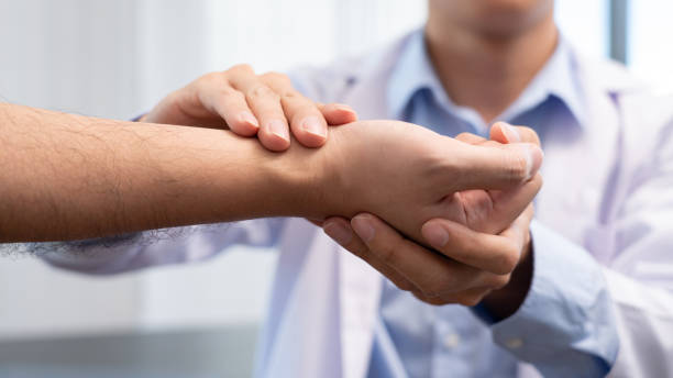 Medical concept a male doctor diagnosing a male patient"u2019s wrist by pressing the wrist bone. Medical concept a male doctor diagnosing a male patient"u2019s wrist by pressing the wrist bone. emergency medicine stock pictures, royalty-free photos & images