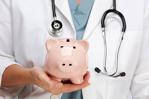 Doctor holding a classic piggy bank stock photo