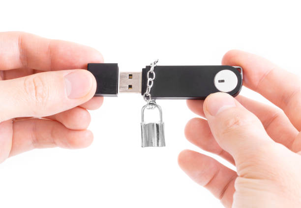 istock Memory stick with a padlock on a chain in male hands isolated on white 1320272740
