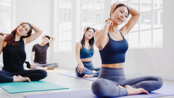 istock Young Asian sporty attractive people practicing yoga lesson with instructor. Asia group of women exercising healthy lifestyle in fitness studio. 1320273466