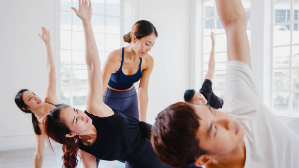 istock Young Asian sporty attractive people practicing yoga lesson with instructor. 1320274691