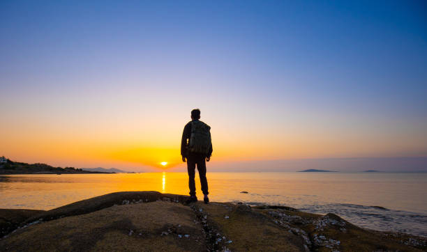 traveler walking on coast looking sunrise