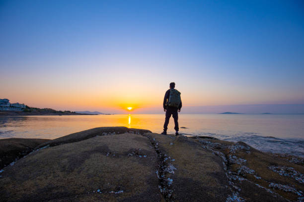 istock traveler walking on coast looking sunrise 1320274908