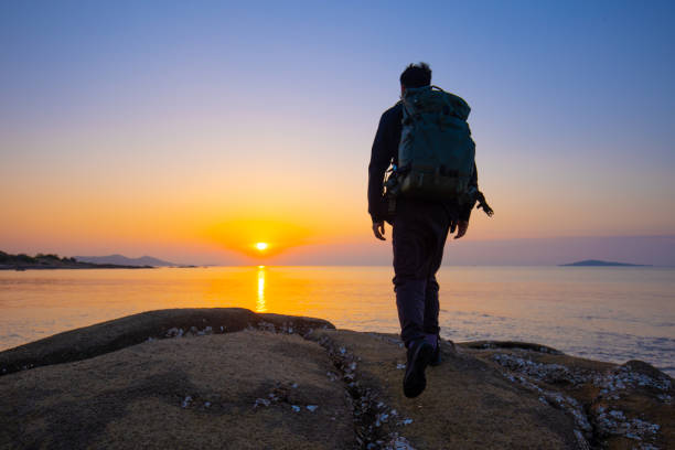 istock traveler walking on coast looking sunrise 1320274909
