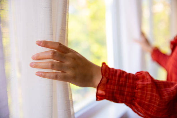istock Close-up hand open window curtain 1320274981