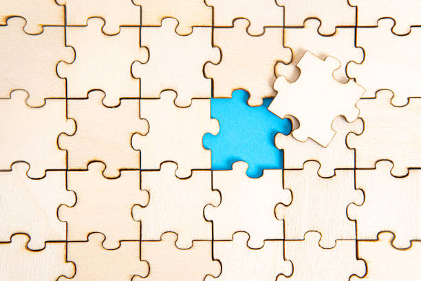 istock Wooden jigsaw puzzle background with the final missing piece 1320275818