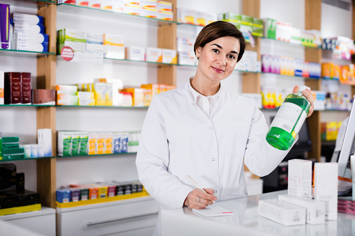 Pharmacist writing prescriptions for medicines in pharmacy