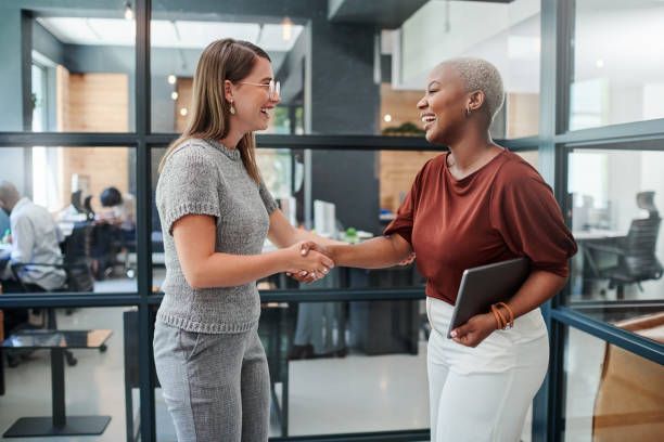 Shot of two businesswomen shaking hands in an office stock photo