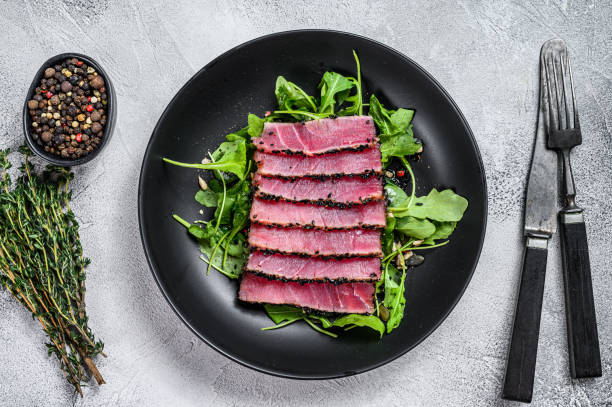 insalata di bistecca di tonno con rucola e spinaci. sfondo bianco. visualizzazione dall'alto - tuna steak grilled tuna food foto e immagini stock