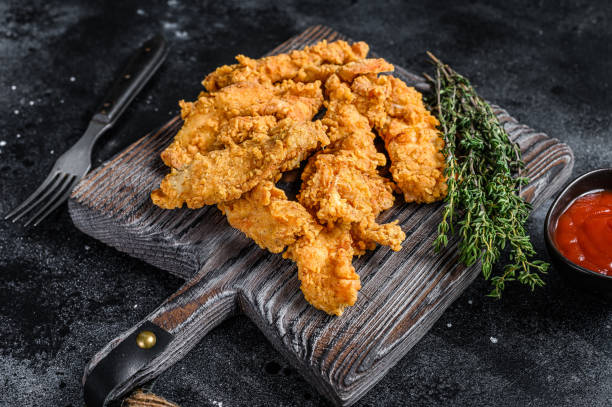 istock Steak Fingers fried breaded chicken breast strips. Black background. Top view 1320279389
