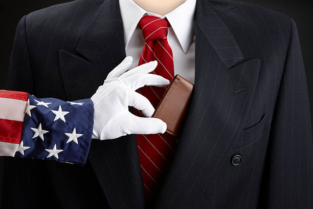 Uncle Sam picks businessman's pocket Close up shot of Uncle Sam picking the pocket of a businessman pickpocketing stock pictures, royalty-free photos & images