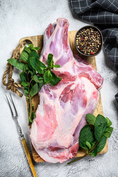 istock Raw goat shoulder meat ready for baking with garlic, mint. White background. Top view 1320280385