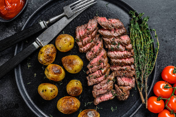 manzo di carne di marmo alla griglia bistecca con patate fritte. sfondo nero. visualizzazione dall'alto - steak strip steak prepared potato grilled foto e immagini stock