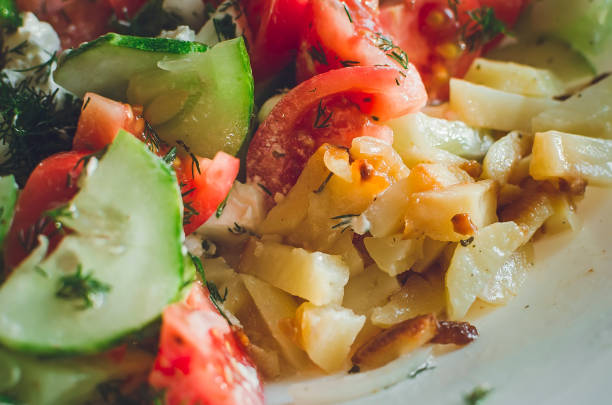 Delicious homemade lunch. Fried potatoes, tomatoes, cucumbers.
