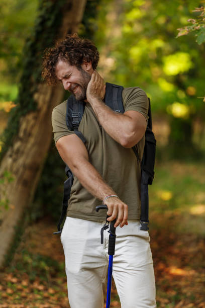 Man is Traveling with Backpack and has Problems with Insects in the Forest. Portrait of a Young Man Scratching his Skin due to Attack From a Large Group of Unpleasant Mosquitoes. backpack sprayer stock pictures, royalty-free photos & images
