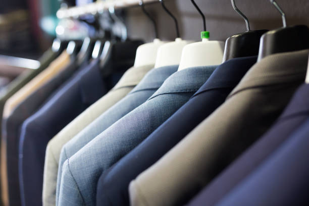 Men suits on hanger racks in shop Assortment of suit jackets on hanger racks in menswear clothing store for selling mens fashion stock pictures, royalty-free photos & images