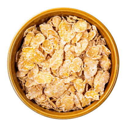 top view of sugar-coated cornflakes in round bowl cutout on white background