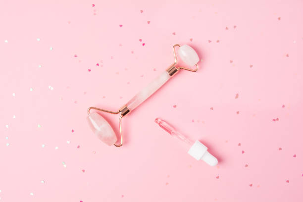 istock Massage quartz roller and dropper with cosmetic product on pink background 1320287817