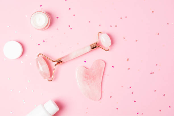 istock Roller and gua sha massage scraper and cometic product on a pink background 1320287819
