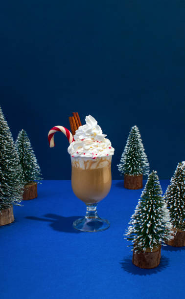 istock Eggnog hot chocolate or latte with cream topping cinnamone sticks and candy cane 1320290742