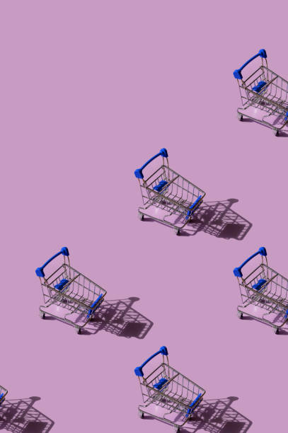 istock Miniature supermarket trolley pattern on pink background. Place for text. 1320290892