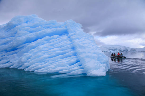 istock Tourists watching large iceberg and glacier passing through Paradise bay 1320292215