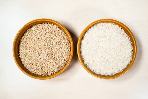vista del arroz de grano medio pulido y sin pulir - dishware brown rice rice variation fotografías e imágenes de stock