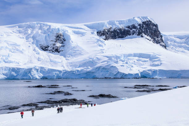 istock Tourists walking on snowy landscape 1320292895