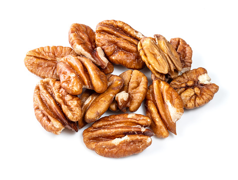 several shelled pecan nuts closeup on white background