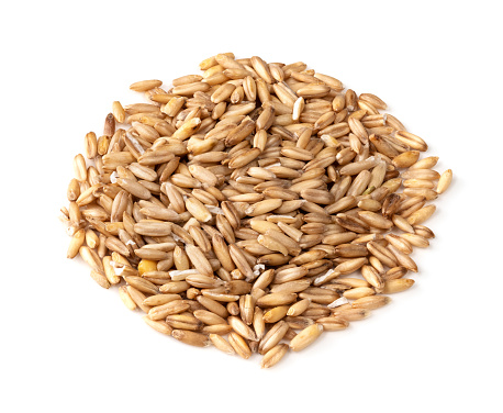 pile of wholegrain oat grains closeup on white background