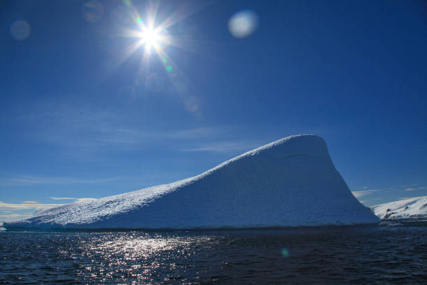 View of iceberg floating in sea against blue sky, Cierva Cove, Trinity Peninsula, Antarctica.