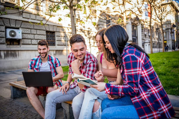 istock Happy young teens group sitting on bench and having fun 1320294286