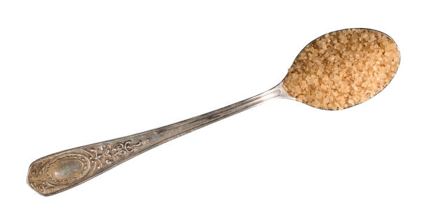 demerara brown sugar in silver teaspoon cutout top view of demerara unrefined cane brown sugar in silver teaspoon cutout on white background tsp stock pictures, royalty-free photos & images