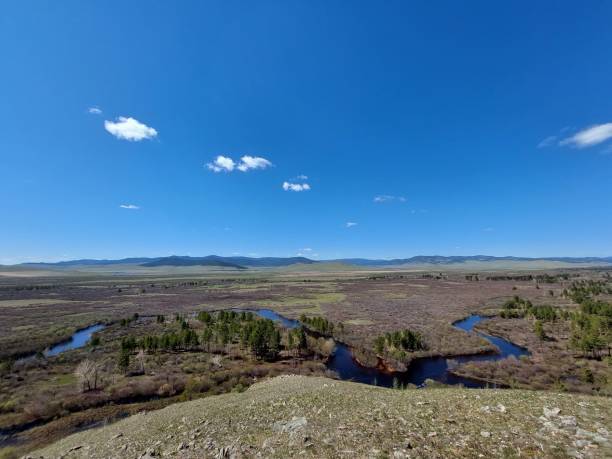 istock River flowing crossing valley and forest Aerial view under Blue Sky reflecting in Water Surface and mountains ridge on horizon 1320295629