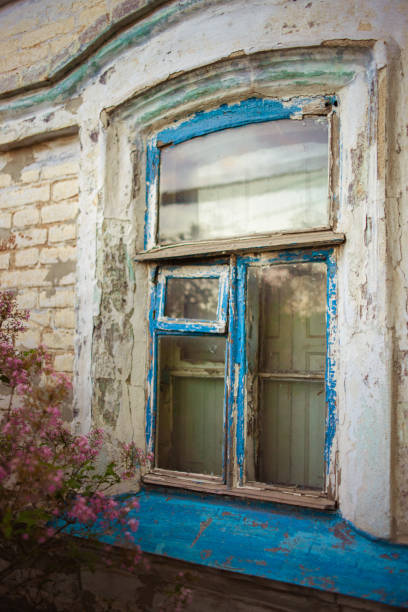 istock Old window with blue wooden frame with peeling paint. Rural house closeup 1320295831