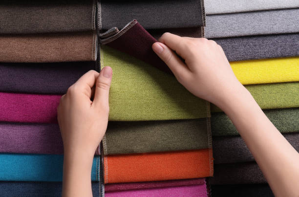 istock Woman choosing among colorful fabric samples, closeup 1320295896