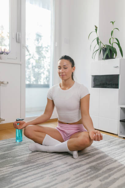 istock Beautiful young woman practicing yoga at home 1320295909