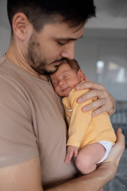 istock Father Bonding With Newborn In Yellow Sleepsuit 1320296527