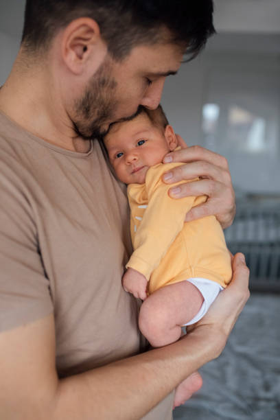 istock Father Bonding With Newborn In Yellow Sleepsuit 1320296529