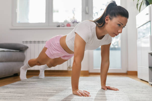 istock Young woman doing push-ups at home 1320296721