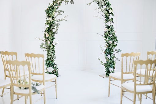 Decorated greenery wedding altar with chairs in the foreground