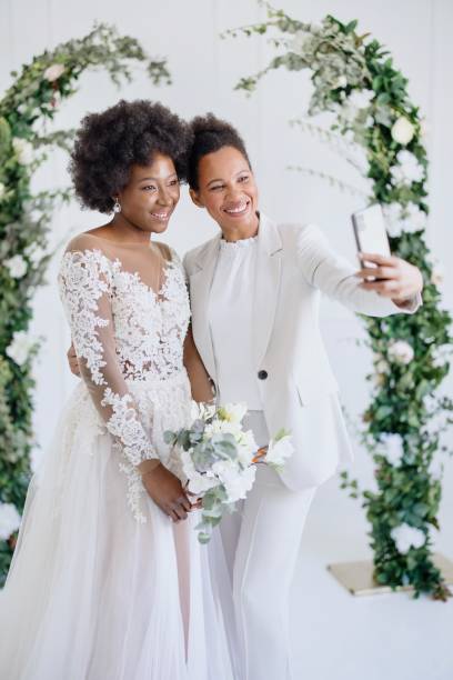 istock Bride and her friend taking selfie at the wedding reception 1320300153
