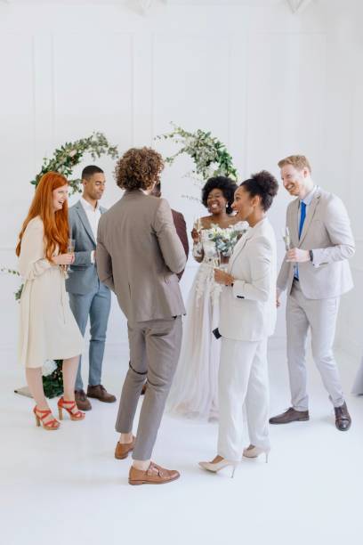 istock Newlyweds and wedding guests laughing and talking during party 1320300211